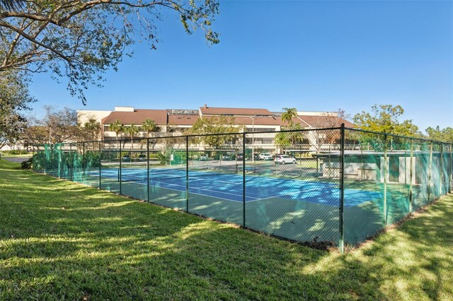 view of tennis court featuring a yard