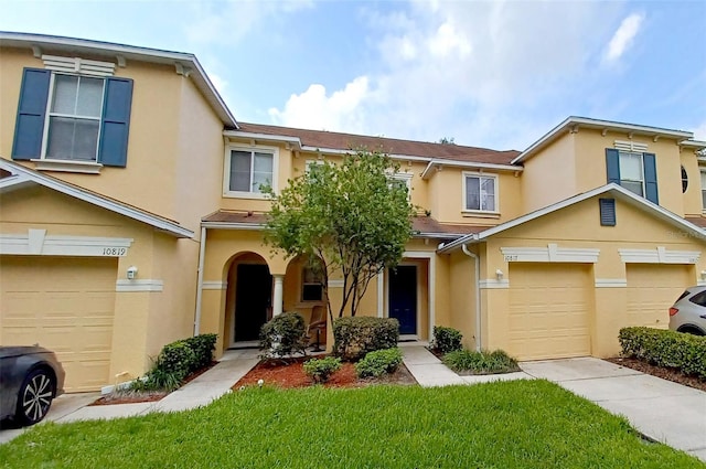 townhome / multi-family property featuring an attached garage and stucco siding