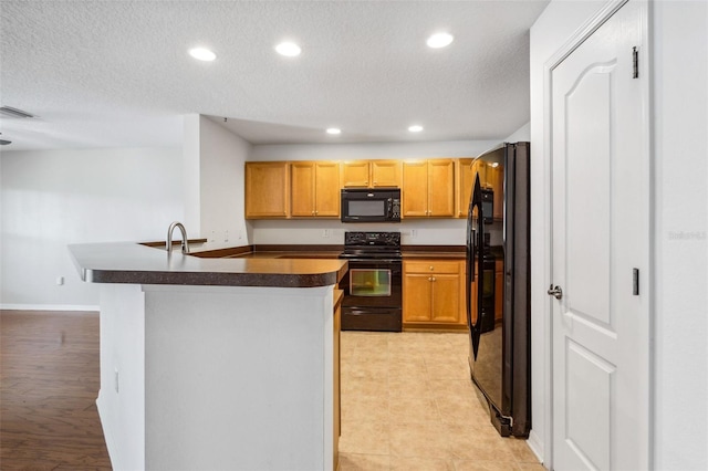 kitchen featuring sink, a textured ceiling, and black appliances