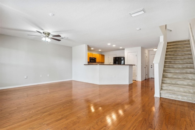 unfurnished living room with a textured ceiling, light hardwood / wood-style flooring, and ceiling fan