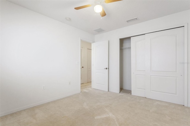 unfurnished bedroom featuring ceiling fan, a closet, and light colored carpet