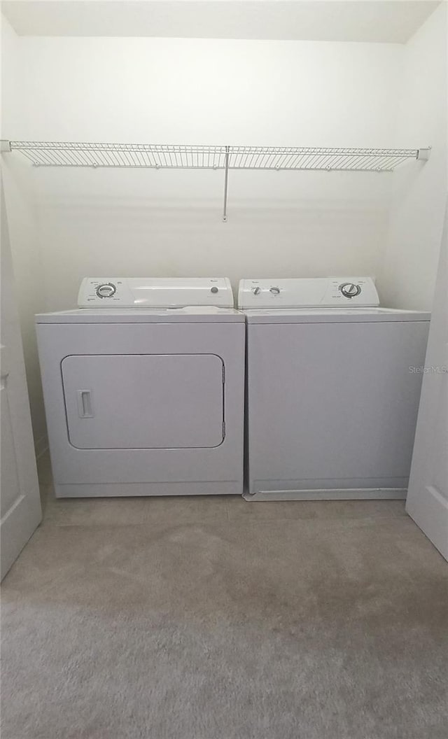 clothes washing area featuring washer and dryer and carpet floors