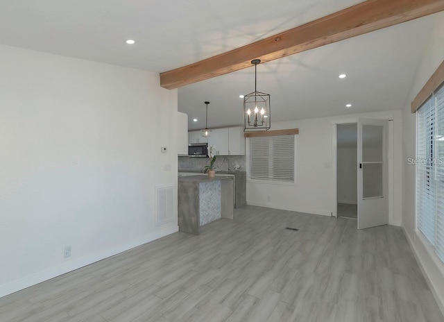 unfurnished living room with vaulted ceiling with beams, light hardwood / wood-style flooring, and a notable chandelier