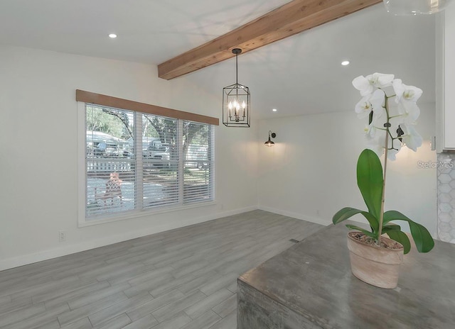 dining area with a chandelier, lofted ceiling with beams, and light hardwood / wood-style flooring