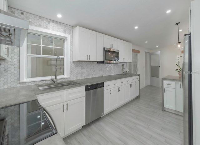 kitchen featuring pendant lighting, white cabinets, sink, tasteful backsplash, and stainless steel appliances