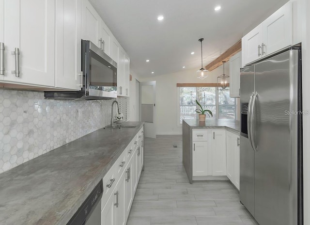 kitchen featuring white cabinetry, sink, pendant lighting, and appliances with stainless steel finishes