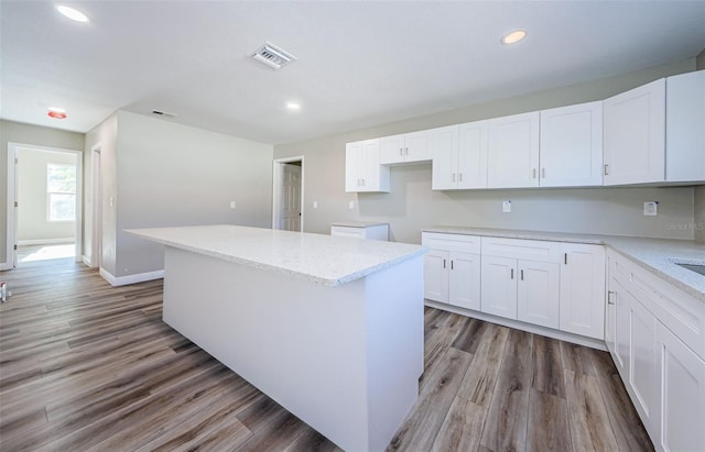 kitchen featuring visible vents, a kitchen island, light wood-type flooring, white cabinetry, and recessed lighting