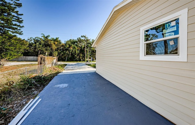 view of property exterior with a patio area and fence