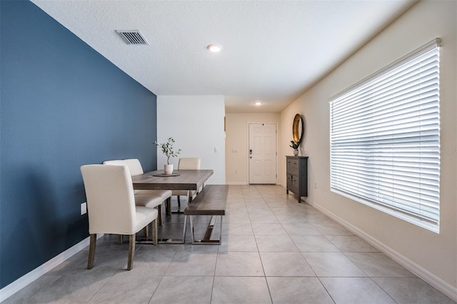 dining space featuring light tile patterned floors and a textured ceiling