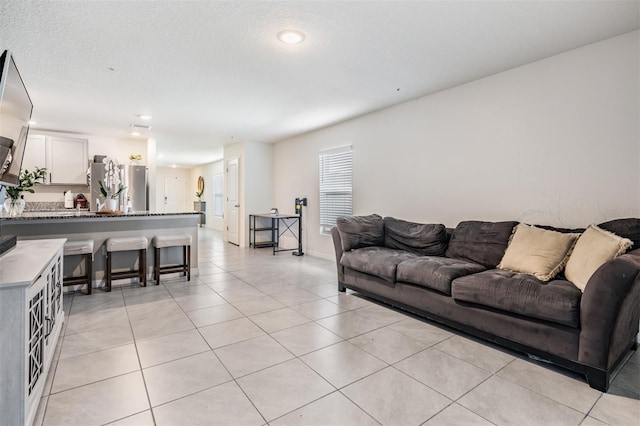 living room featuring light tile patterned floors and a textured ceiling