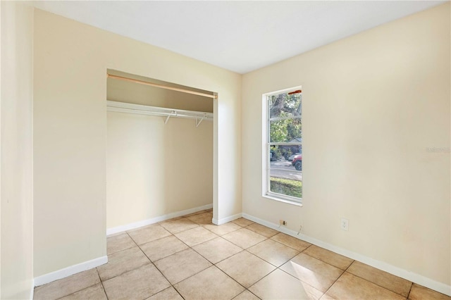 unfurnished bedroom with light tile patterned floors and a closet