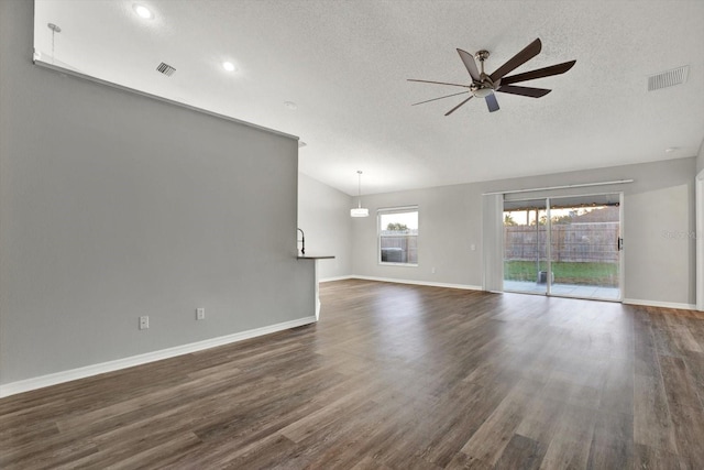 unfurnished living room with a textured ceiling, dark hardwood / wood-style floors, and ceiling fan