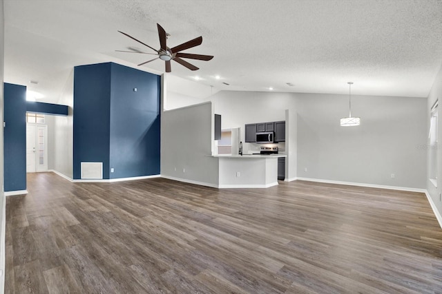 unfurnished living room with a textured ceiling, dark hardwood / wood-style flooring, vaulted ceiling, and ceiling fan