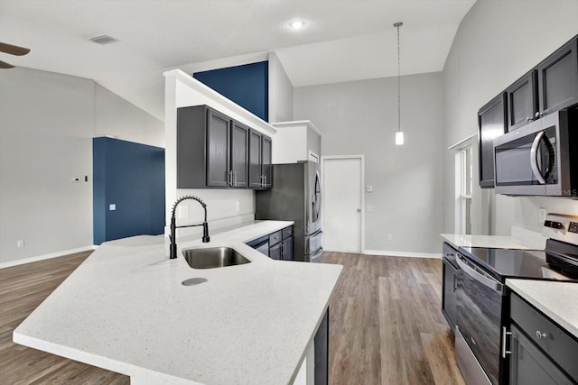 12612 Midpointe Dr, Riverview, FL 33579 - kitchen featuring stainless steel appliances, a sink, high vaulted ceiling, baseboards, and wood finished floors