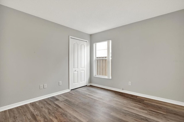 12612 Midpointe Dr, Riverview, FL 33579 - unfurnished bedroom with dark wood finished floors, baseboards, and a closet