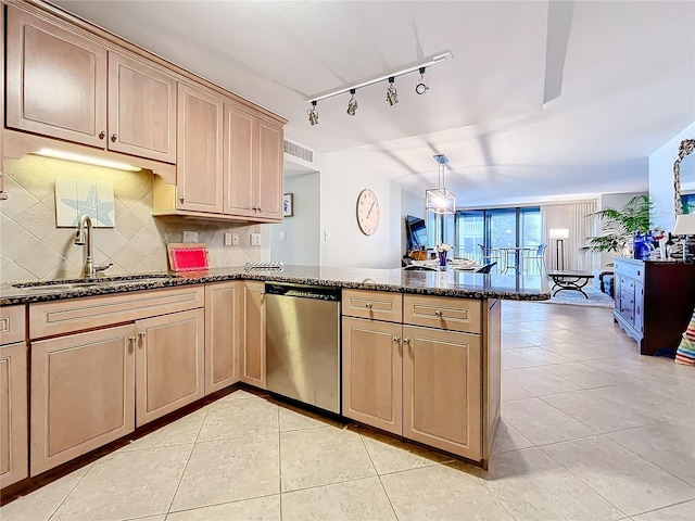 kitchen with kitchen peninsula, sink, light tile patterned floors, dark stone countertops, and dishwasher