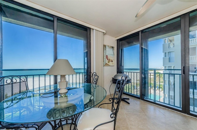 balcony with ceiling fan and a water view