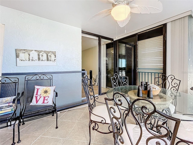 dining space with ceiling fan and tile patterned flooring