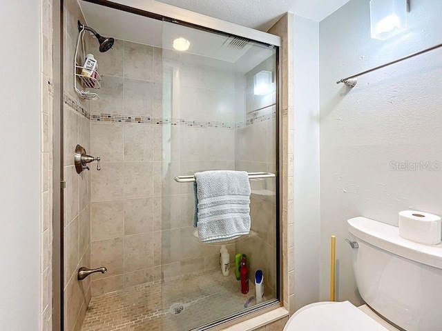 bathroom with toilet and an enclosed shower