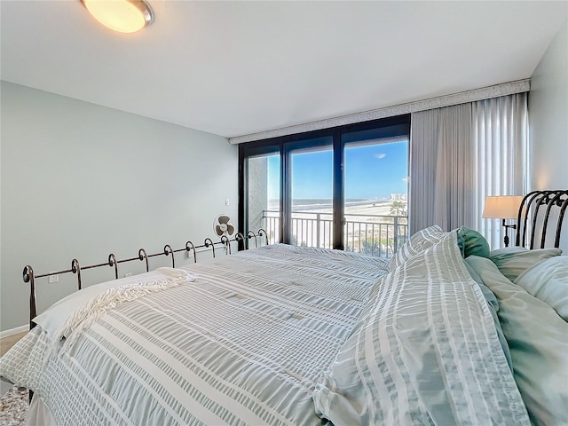 bedroom featuring a wall of windows and access to outside