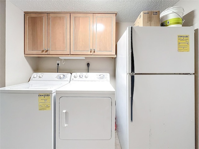 clothes washing area featuring cabinets, separate washer and dryer, and a textured ceiling