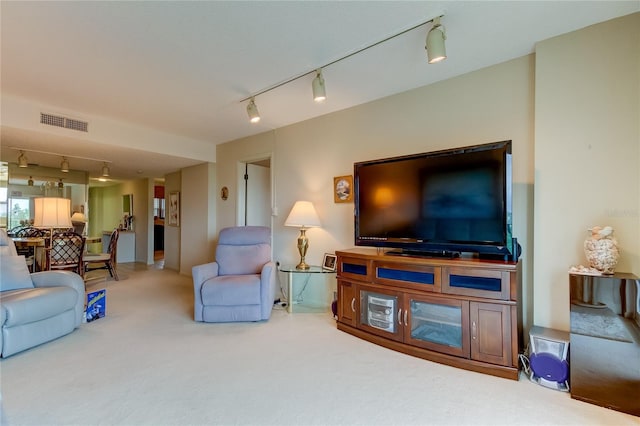 carpeted living room featuring track lighting