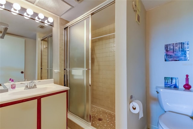 bathroom featuring vanity, toilet, and a shower with shower door