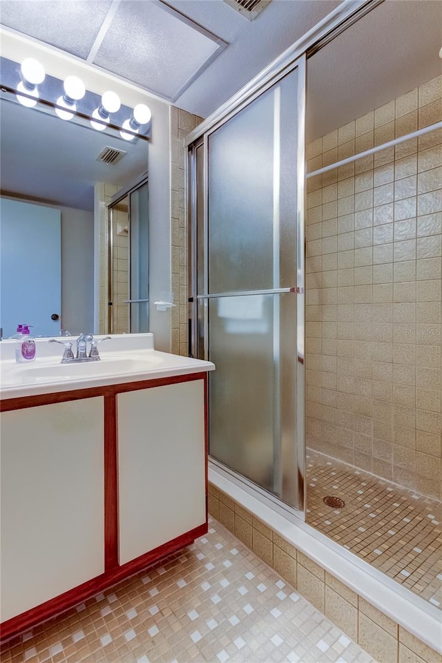 bathroom featuring tile patterned flooring, vanity, and a shower with shower door