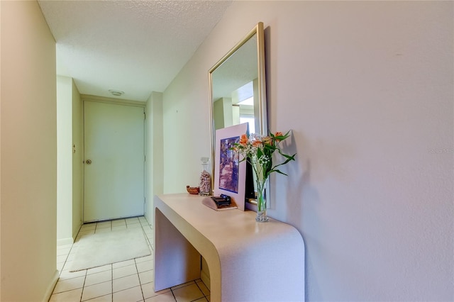 hallway with light tile patterned flooring and a textured ceiling