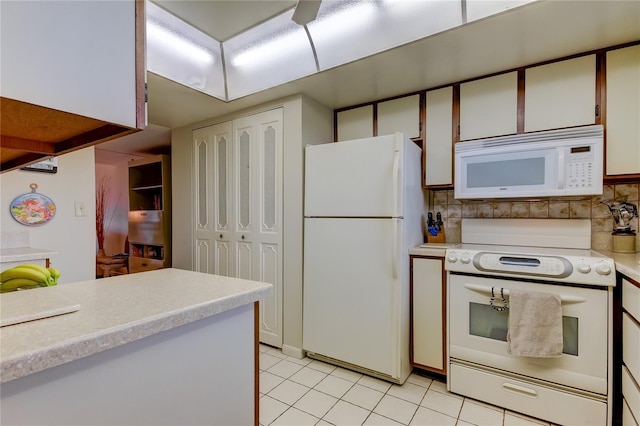 kitchen featuring white cabinetry, light tile patterned flooring, white appliances, and tasteful backsplash