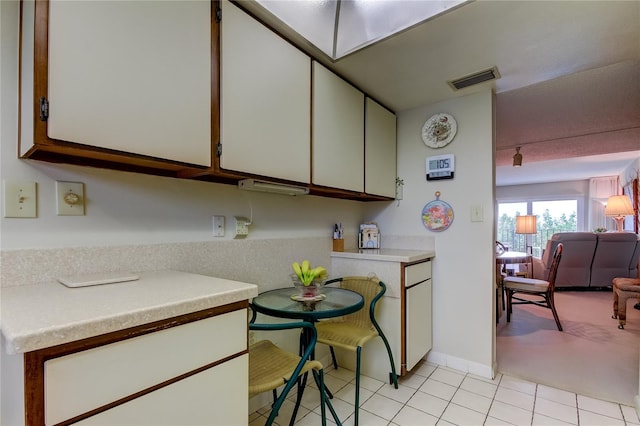 kitchen with light tile patterned flooring and white cabinetry