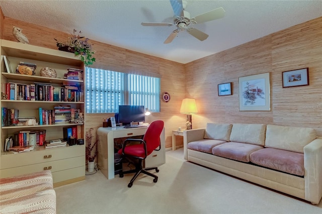 carpeted office space with ceiling fan and a textured ceiling