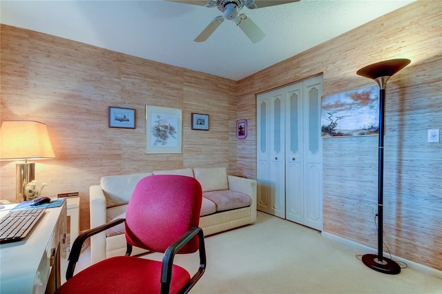 carpeted office space with ceiling fan