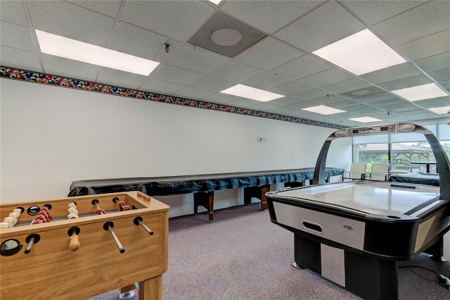 recreation room featuring a paneled ceiling and light colored carpet