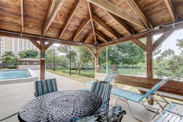 view of patio / terrace featuring a gazebo, a water view, and a pool