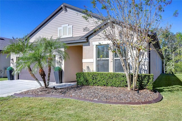 view of front of property featuring a front yard and a garage