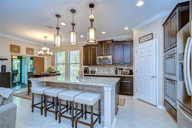 kitchen with sink, ornamental molding, decorative light fixtures, and appliances with stainless steel finishes