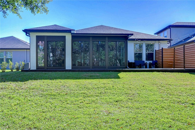 back of property with a sunroom and a yard