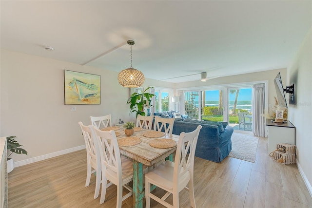 dining room with baseboards, ceiling fan, and light wood-style floors