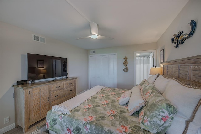 bedroom with a ceiling fan, a closet, visible vents, and wood finished floors