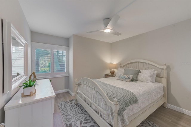 bedroom with light wood-type flooring, ceiling fan, and baseboards