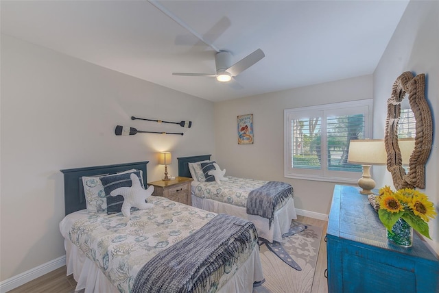 bedroom featuring baseboards, ceiling fan, and light wood-style floors