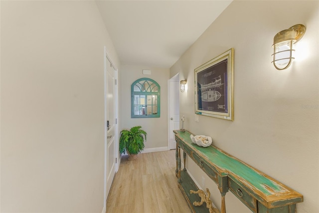 doorway to outside with light wood-style flooring and baseboards