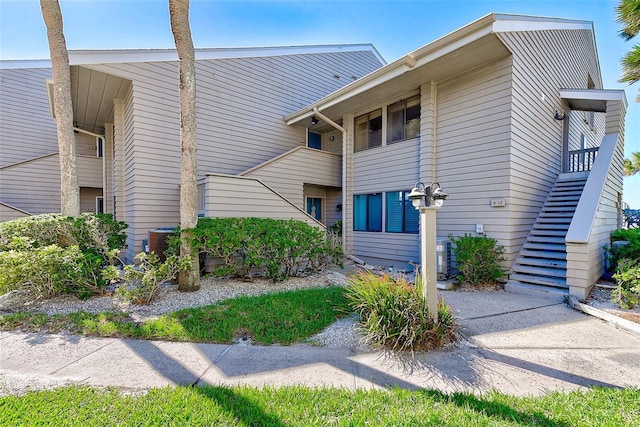 view of side of property featuring stairs and central AC unit