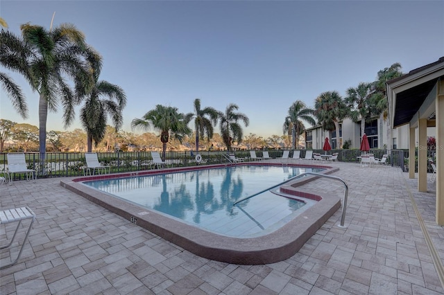 pool with a patio and fence