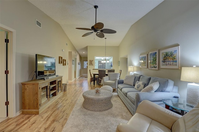 living room featuring visible vents, light wood-style floors, ceiling fan, and high vaulted ceiling