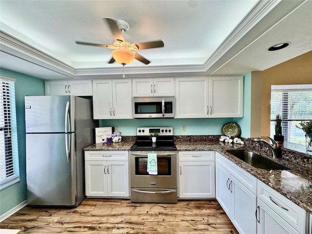 4452 Weybridge St Unit 74, Sarasota, FL 34235 - kitchen with appliances with stainless steel finishes, light wood-style flooring, a raised ceiling, and white cabinetry
