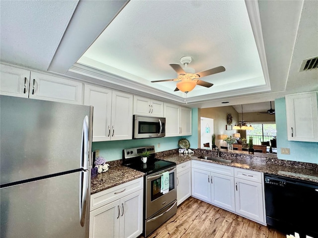 4452 Weybridge St Unit 74, Sarasota, FL 34235 - kitchen with appliances with stainless steel finishes, a tray ceiling, ceiling fan, white cabinets, and a textured ceiling