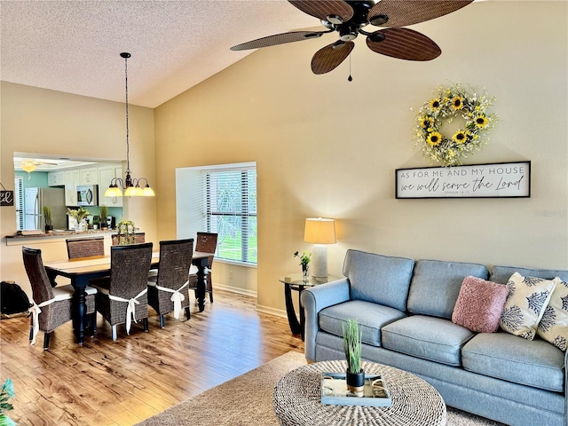 4452 Weybridge St Unit 74, Sarasota, FL 34235 - living area with ceiling fan, light wood-type flooring, high vaulted ceiling, and a textured ceiling