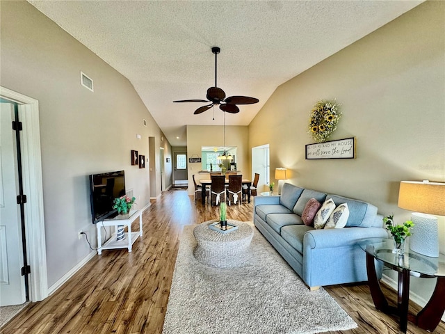 4452 Weybridge St Unit 74, Sarasota, FL 34235 - living room with wood finished floors, vaulted ceiling, a textured ceiling, and ceiling fan